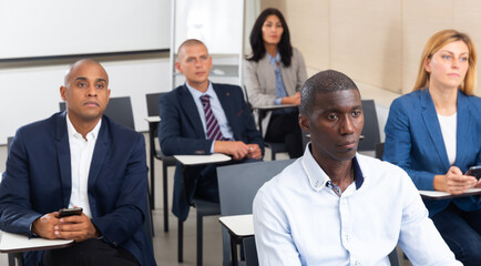 Portrait of young focused aframerican businessman participating in corporate seminar in conference room ..