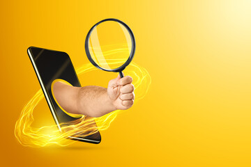 The hand crawling out through the smartphone holds, offers a magnifying glass on a yellow...