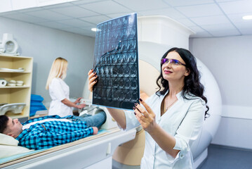 Radiologist with a male patient examining a mri scan
