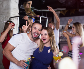 portrait of man and woman dancing and hugging on party in the club