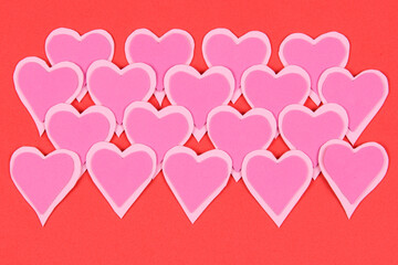pink hearts overlaid on red background to remind valentine's day