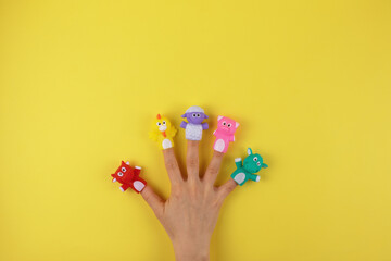 Female hand with 5 finger dolls: cow, sheep, chicken, pig. The concept of child development. Place to copy. Flat lay.