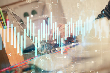 Double exposure of woman hands typing on computer and forex chart hologram drawing. Stock market...
