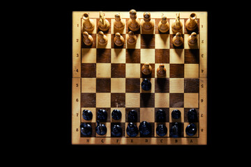 Retro chess board with figures from USSR on a black background. Chess opening Queen Gambit, top view