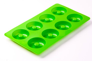 Green silicone shape donut isolated on white background. Bakeware.