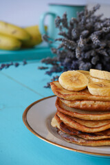 Delicious pancakes with banana and on blue wooden table. Breakfast time 