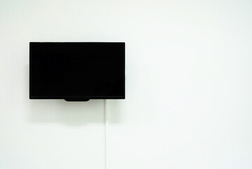 Blank Television Monitor on White Concrete Wall, Suitable for Advertising.