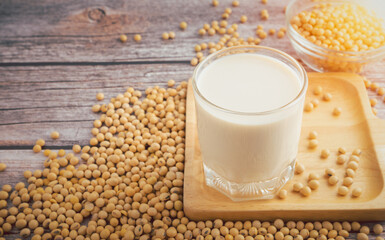 Obraz na płótnie Canvas Soy milk and Soybeans in glass bowl on wooden table background.Healthy food Concept.