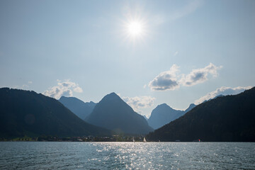 lake Achensee, view to tourist area Pertisau, blue sky with bright sun