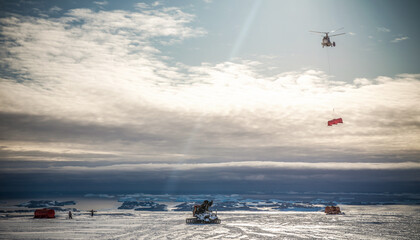 Aviation unloading cargo at ice with helicopter at coast Antarctic.