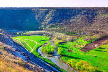 Green riverside valley . Spectacular spring landscape . Flowing river and green meadows with hills scenery 