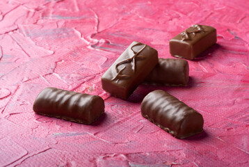 Five candies with milk chocolate on a bright background. Sweets for tea.