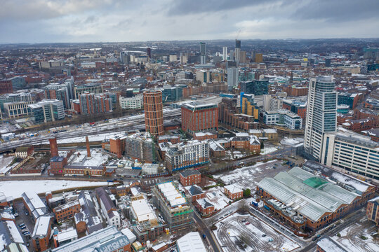 Aerial photo of the town centre of Leeds in West Yorkshire, near the Bridgewater Place apartment building along side the Leeds Train Station in the snow and winter time