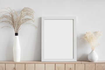 Blank picture frame mockup on white wall. White living room design. View of modern scandinavian style interior. Home staging and minimalism concept	
