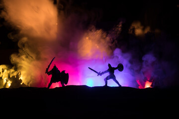 Fototapeta premium Medieval battle scene with cavalry and infantry. Silhouettes of figures as separate objects, fight between warriors on sunset foggy background.