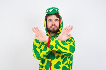 Fototapeta premium Young caucasian man wearing a pajama standing against white background has rejection expression crossing arms and palms doing negative sign, angry face.