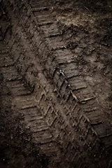 Poster Tyre track on dirt sand or mud, Picture in retro or grunge tone. Car drive on sand. off road track. Track on grass field. Track in farm. © surawach5