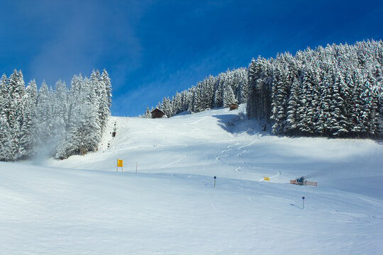 The 'Kleinberg' ski slope in wintertime with active snow cannon and fair weather in Filzmoos (Salzburg county, Austria)