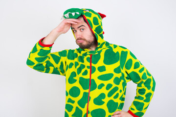 Young caucasian man wearing a pajama standing against white background having problems, worried and stressed holds hand on forehead.