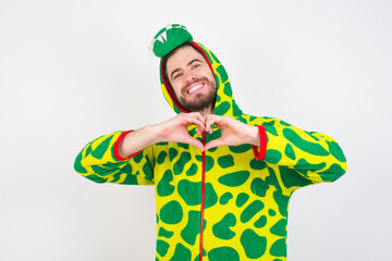 Fototapeta premium Young caucasian man wearing a pajama standing against white background smiling in love doing heart symbol shape with hands. Romantic concept.