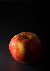 An apple against black background