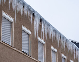 Eiszapfen hängen an einem  Dach herunter