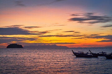 Fototapeta na wymiar Sunrise skyline seascape with silhouette boat and islands background on twilight sky