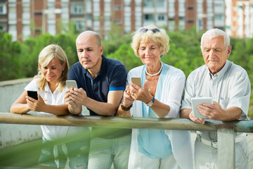 mature people chatting in smartphone in the outdoor