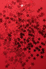 Red confetti in the form of stars on a red background