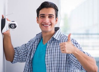 Man installing surveillance CCTV cameras at home