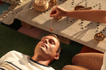 Man at crystal healing session indoors, closeup