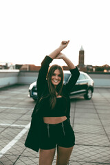 Junge hübsche Frau posiert mit einem Auto auf dem Parkdeck