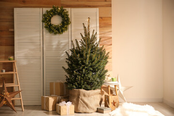 Spacious room interior with small Christmas tree and wreath