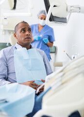 Fototapeta premium Patient is afraid to have his teeth treated at the dentist