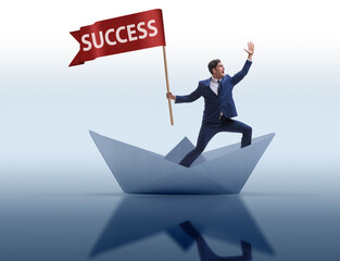 Businessman riding paper boat ship in success concept