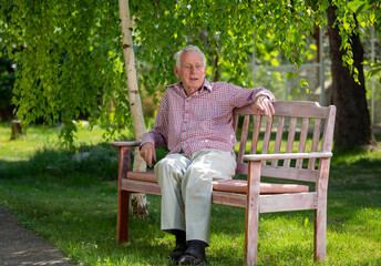Fototapeta premium Old man sitting in park