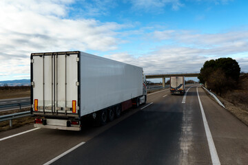 Camión frigorífico con temperatura controlada que transporta mercancías por carretera adelantando en la autovía.