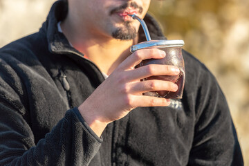 young man drinking mate tea close up