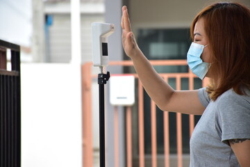 A woman was to check his body temperature. With floor-standing infrared thermometers To screen...