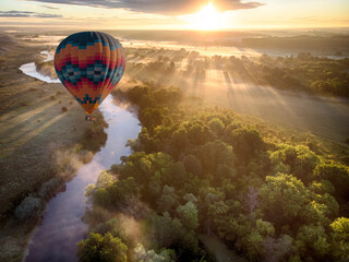 Hot air balloon over river on sunset. Travel, freedom, adventure, exploration, extreme concept. © Kotangens