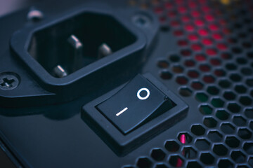 Computer power supply power on button close up in dark colors
