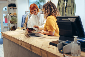 Fashion shop owners checking online orders