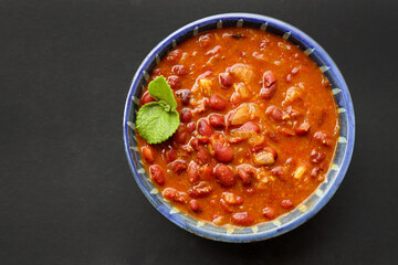 Rajma curry is a popular North Indian Food. Rajma is a socked Red kidney beans cooked with onions, tomatoes and a special blend of spices. Served with Jeera rice or Cumin Rice. With Copy Space.