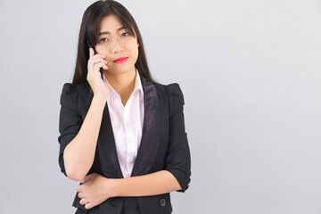 Asian women in suit standing posing using  phone