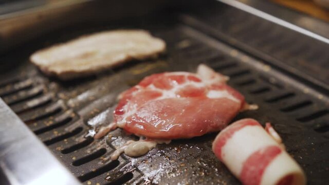 Grilling Of Samgyeopsal, Moksal, And Daejjikalbi In A Grilling Table In a Korean Restaurant. -Wide Shot