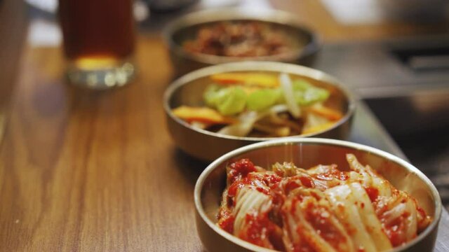 Various Banchan Served At A Wooden Table In A Korean Restaurant. - close up