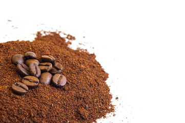 Roasted coffee beans at the top of a pile of ground coffee on an isolated white background. With white area for copy space text.