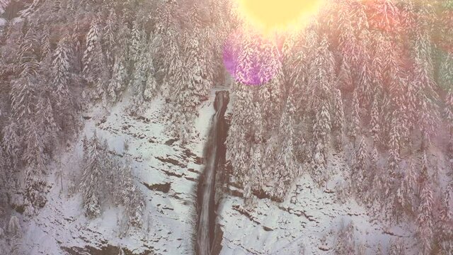 A Reveal of the Cascade du Rouget covered in snow during winter, French Alps