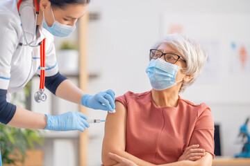 Fototapeta premium Doctor giving a senior woman vaccination