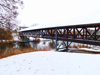 Die überdachte Pionierbrücke über den Fluss im Winter